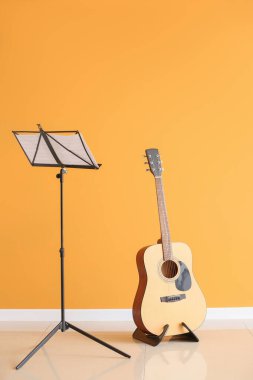 Not standı ve gitarı renk duvarına yakın