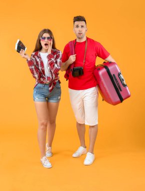 Arka planda bavulu olan endişeli turistler