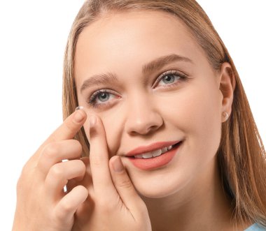 Beyaz arka plana kontak lens takan genç bir kadın