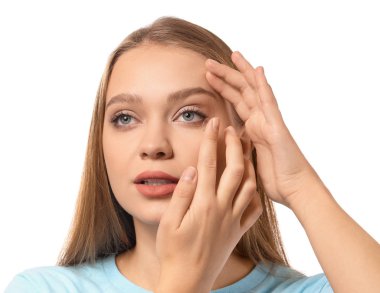 Beyaz arka plana kontak lens takan genç bir kadın