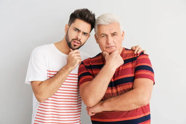 Bedachtzame Jongeman Zijn Vader Lichte Achtergrond — Stockfoto