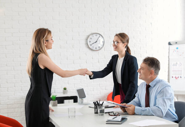 Human resources manager shaking hands with applicant after successful interview