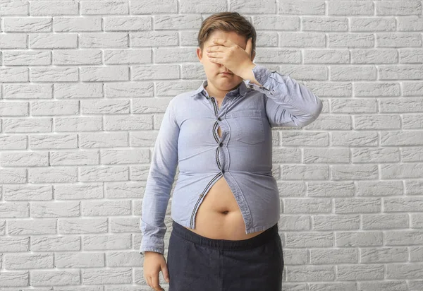 Triste Menino Com Sobrepeso Roupas Apertadas Perto Parede Tijolo — Fotografia de Stock