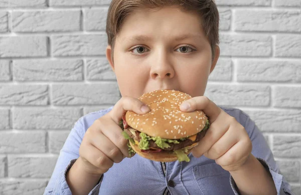 Túlsúlyos Fiú Hamburgerrel Közel Téglafal — Stock Fotó