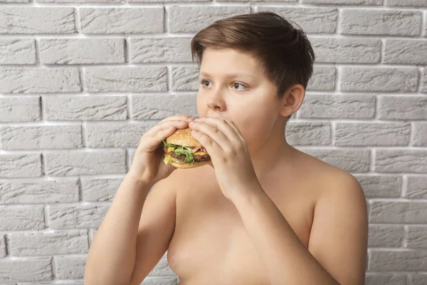 Niño Con Sobrepeso Con Hamburguesa Cerca Pared Ladrillo — Foto de Stock