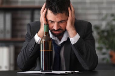 Ofiste şarap içen bir iş adamı. Alkolizm kavramı