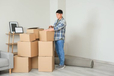 Asyalı adam taşınma gününde eşyalarını topluyor.