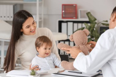 Küçük bebek li kadın klinikte çocuk doktorunu ziyaret etti