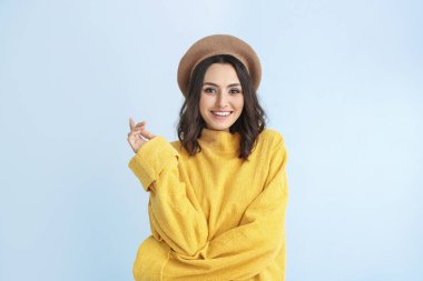 Arka planda kalın süveter giyen güzel bir kadın.