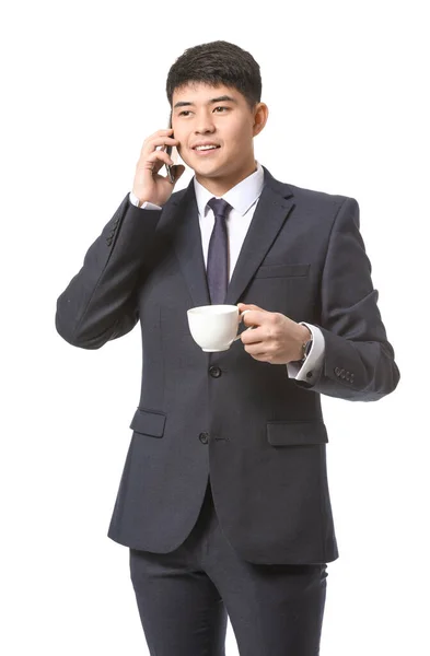 白い背景に電話で話すコーヒーと若いアジアのビジネスマン — ストック写真