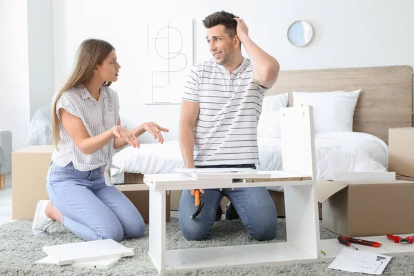 Emotional couple during assembling furniture at home