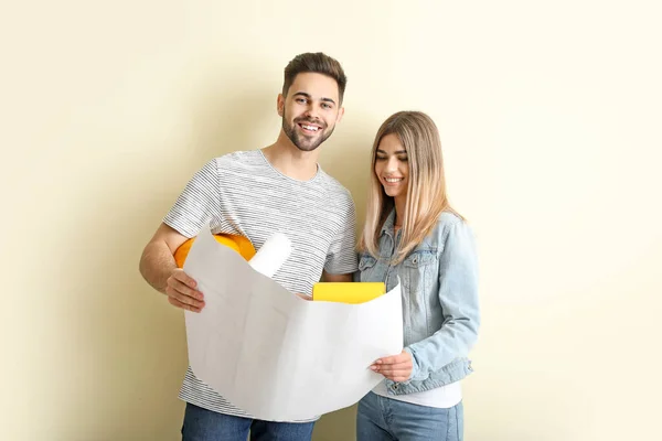 Feliz Pareja Joven Con Plan Nueva Casa Cerca Pared Color — Foto de Stock