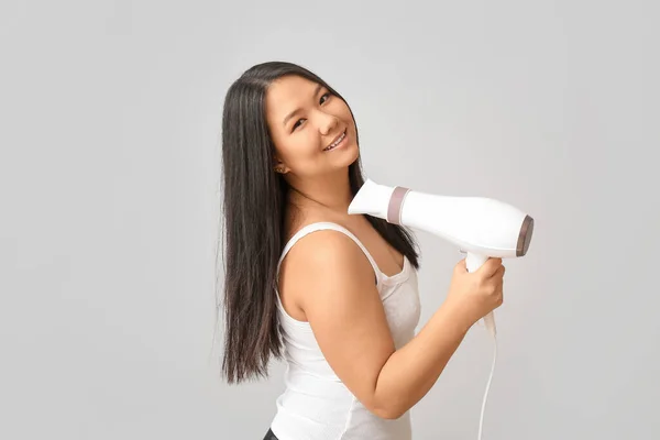 Mulher Asiática Bonita Com Secador Cabelo Fundo Claro — Fotografia de Stock