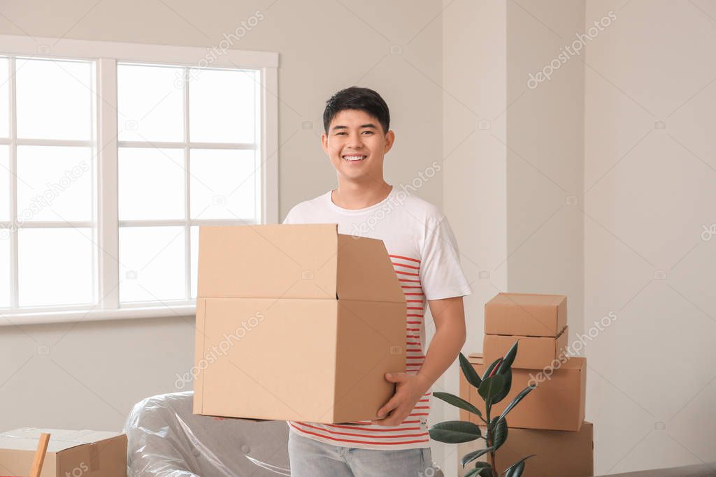 Asian man with belongings at home on moving day