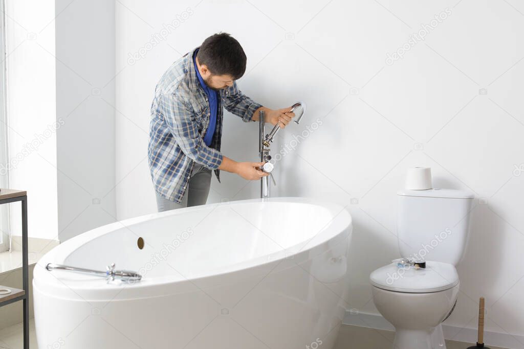 Plumber repairing water tap in bathroom
