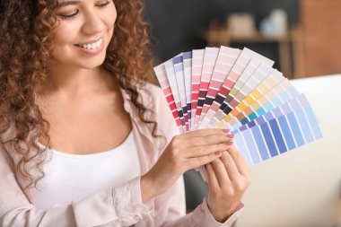 African-American designer with color palettes in office clipart