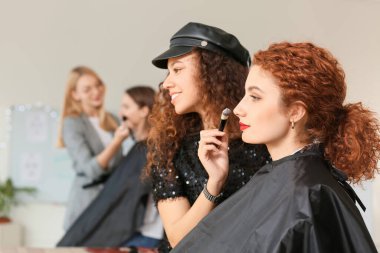 Makyaj okulunda modellik yapan genç bir kadın.
