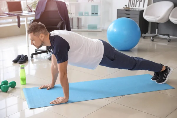 Man doing exercises in office