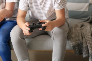 Little children playing video games at home