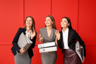 Renk arkaplanı klasörleri olan güzel iş kadınları