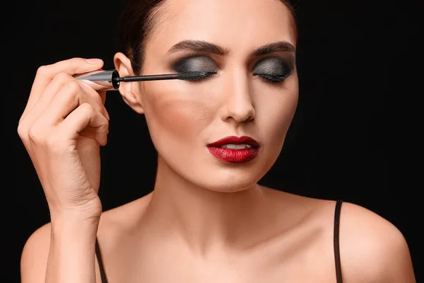 Beautiful Young Woman Applying Makeup Dark Background — Stock Photo, Image