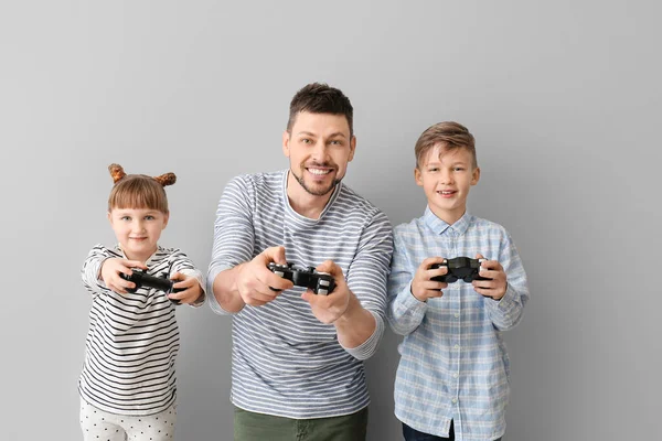 Pai Seus Filhos Pequenos Jogando Videogames Fundo Cinza — Fotografia de Stock