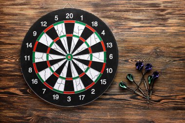 Ahşap zemin üzerinde dart tahtası olan oklar