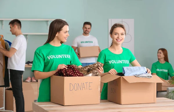 Volunteers with donations for poor people indoors