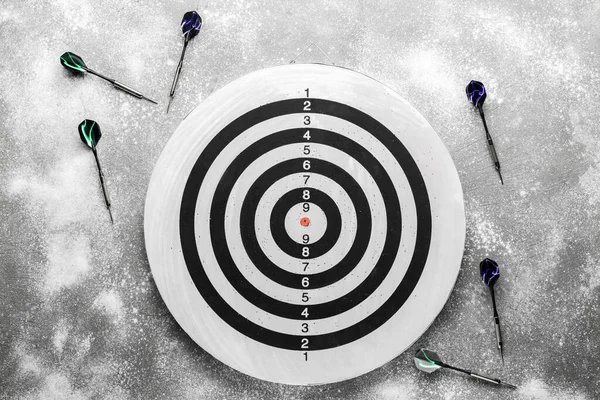 Gri arkaplanda dart tahtası olan dartlar