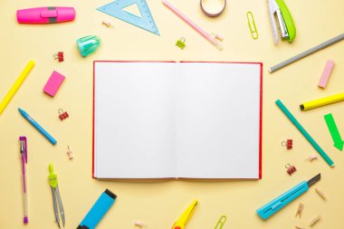 Renkli arka planda okul malzemelerinin olduğu defter
