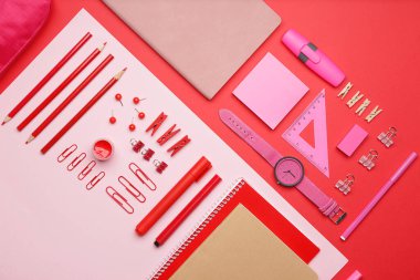 Renkli arkaplan üzerinde saati olan okul gereçleri