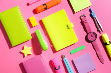 Renkli arkaplan üzerinde saati olan okul gereçleri