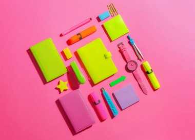 Renkli arkaplan üzerinde saati olan okul gereçleri