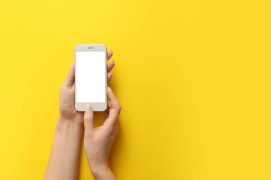 Renkli arka planda cep telefonu olan kadın elleri