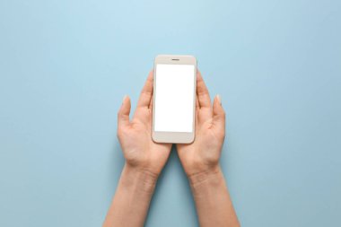 Renkli arka planda cep telefonu olan kadın elleri