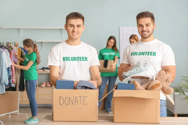 Volunteers with donations for poor people indoors