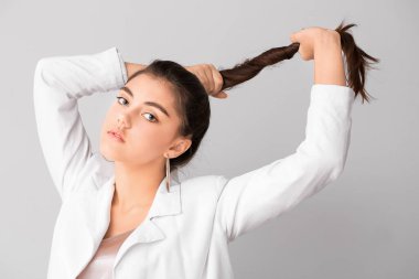 Açık arkaplanda uzun saçlı güzel bir genç kadın.