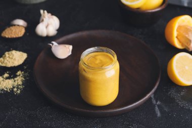 Koyu arkaplanda ballı hardal sosu kavanozu