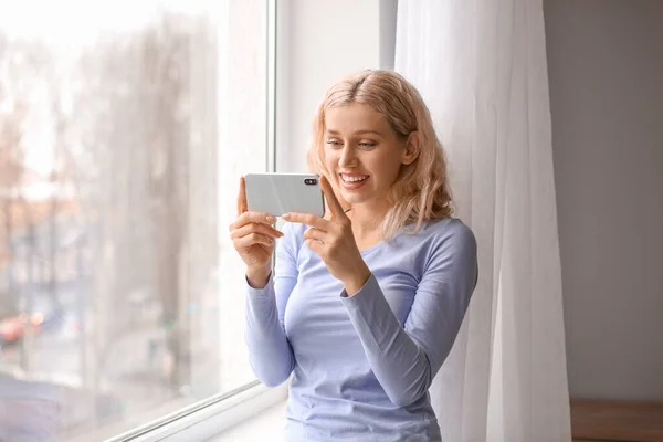 Mladá Žena Mobilním Telefonem Blízkosti Okna — Stock fotografie