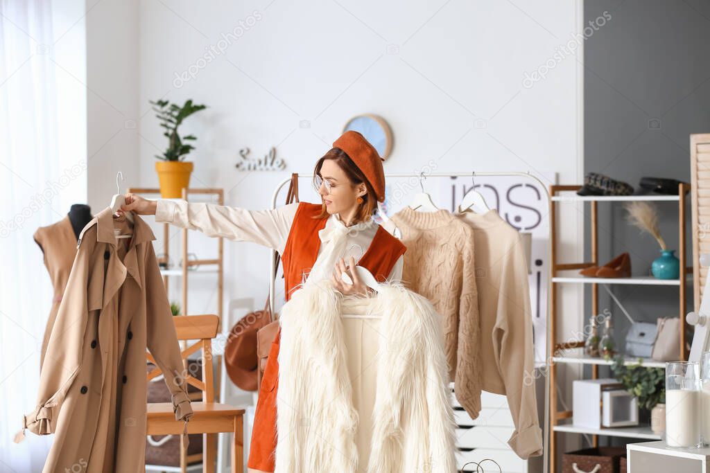 Female stylist with modern clothes in her studio