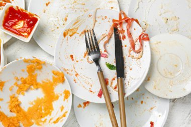 Işık arkaplanındaki kirli boş sofra takımı