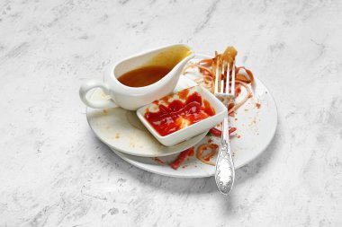 Işık arkaplanındaki kirli boş sofra takımı