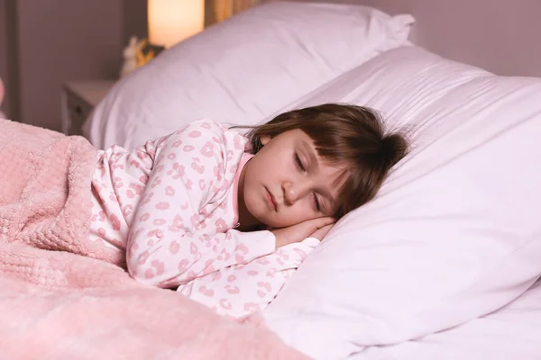 可爱的小女孩晚上睡在床上 — 图库照片