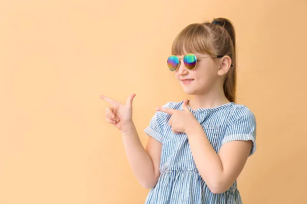 Güneş Gözlüklü Komik Küçük Kız Arka Plandaki Bir Şeyi Işaret — Stok fotoğraf