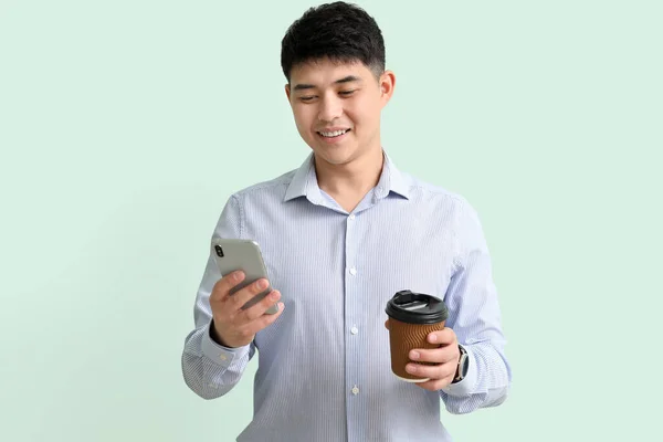 Mladý Asijský Podnikatel Mobilním Telefonem Kávou Barevném Pozadí — Stock fotografie