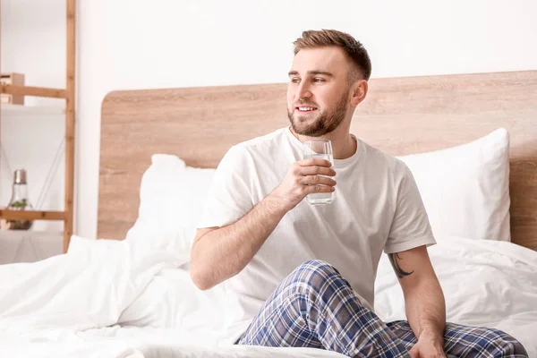 寝室で水を飲む若い男の朝 — ストック写真