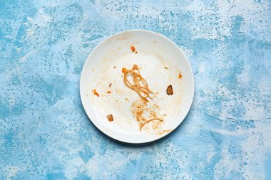 Dirty empty plate on color background clipart