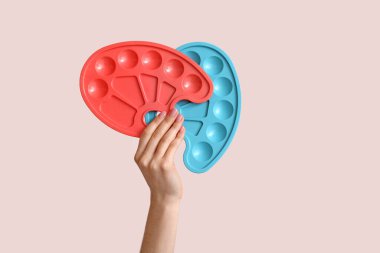 El ve arka planda boya paletleri