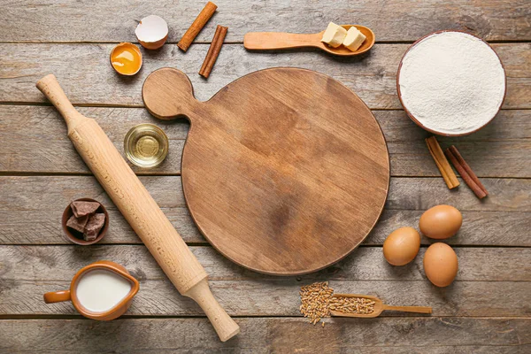 Ingredients for preparing bakery and utensils on wooden background