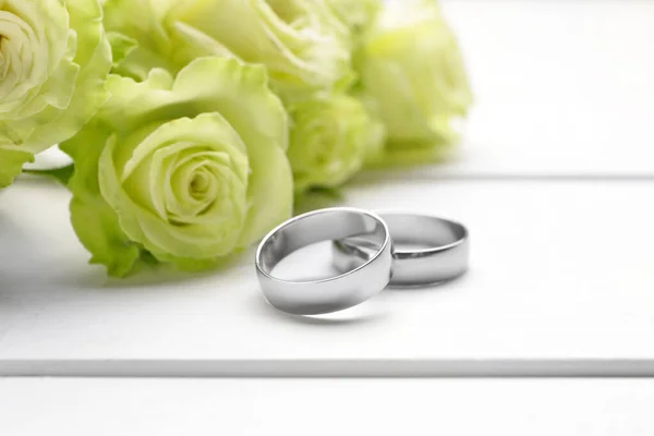Gyönyörű Jegygyűrűk Virágokkal Asztalon — Stock Fotó